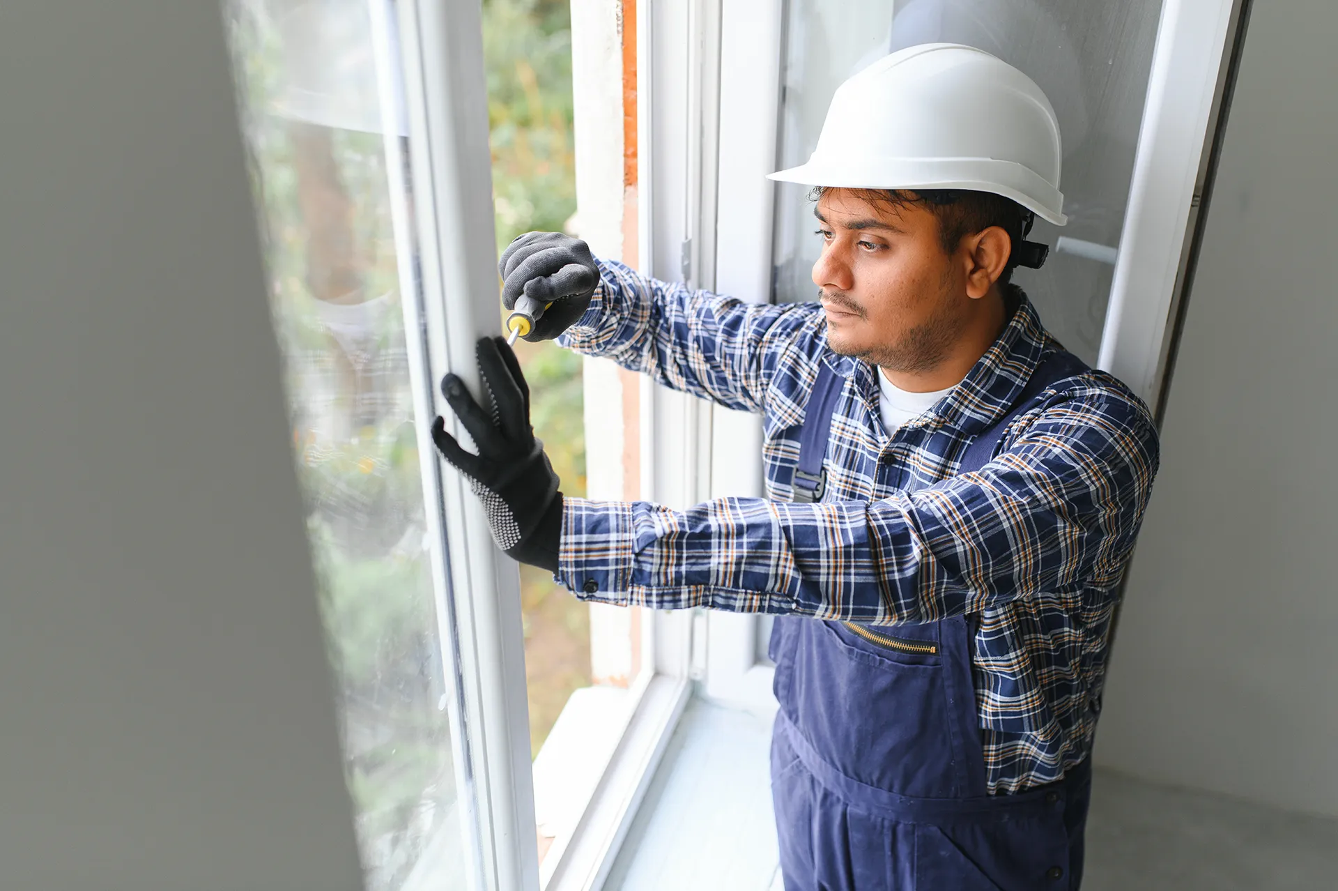 technician servicing windows to weatherize home within service areas