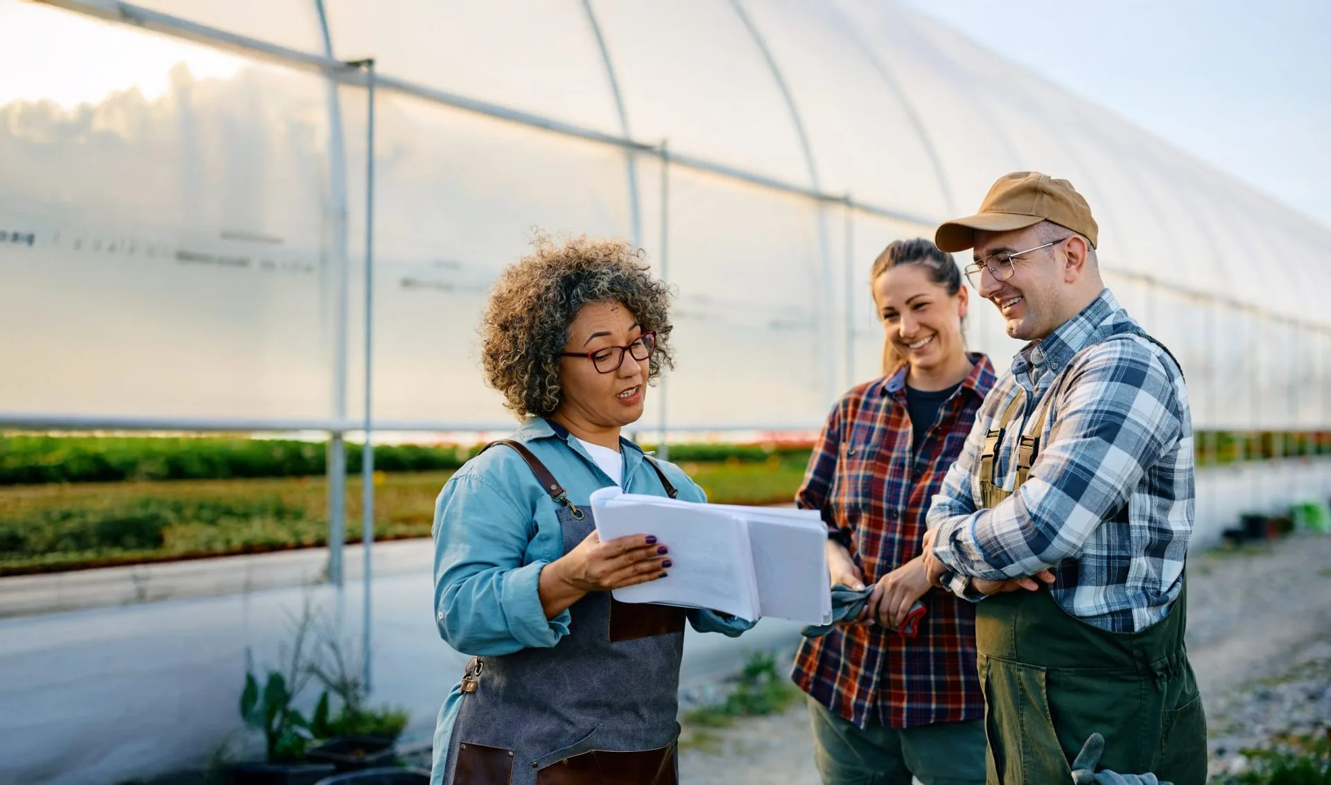 Small business owner going through paperwork with her workers at garden center and review success stories