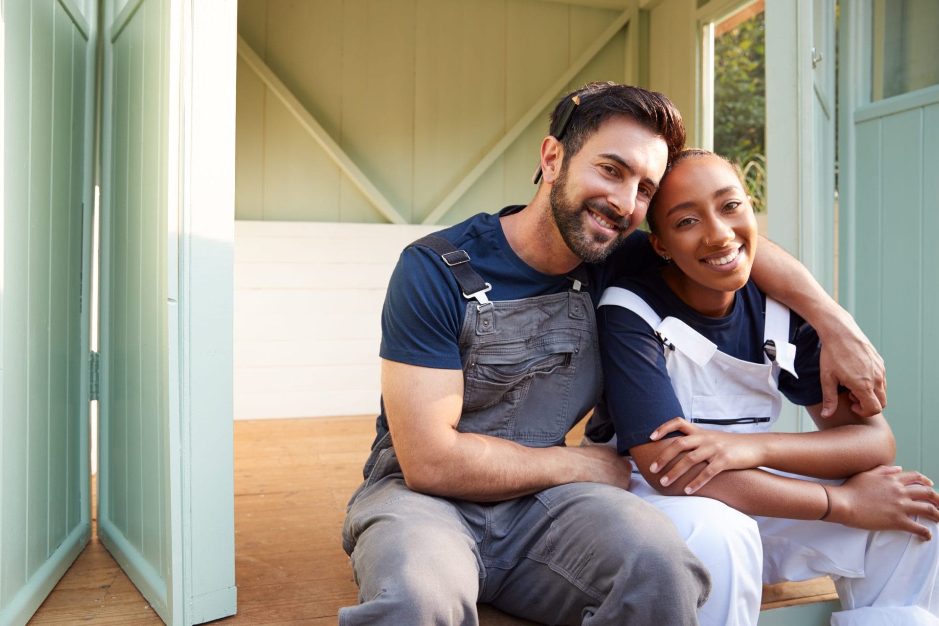 Portrait Of Couple Taking A Break From Building Outdoor Summerhouse In Garden with help from resurgence program