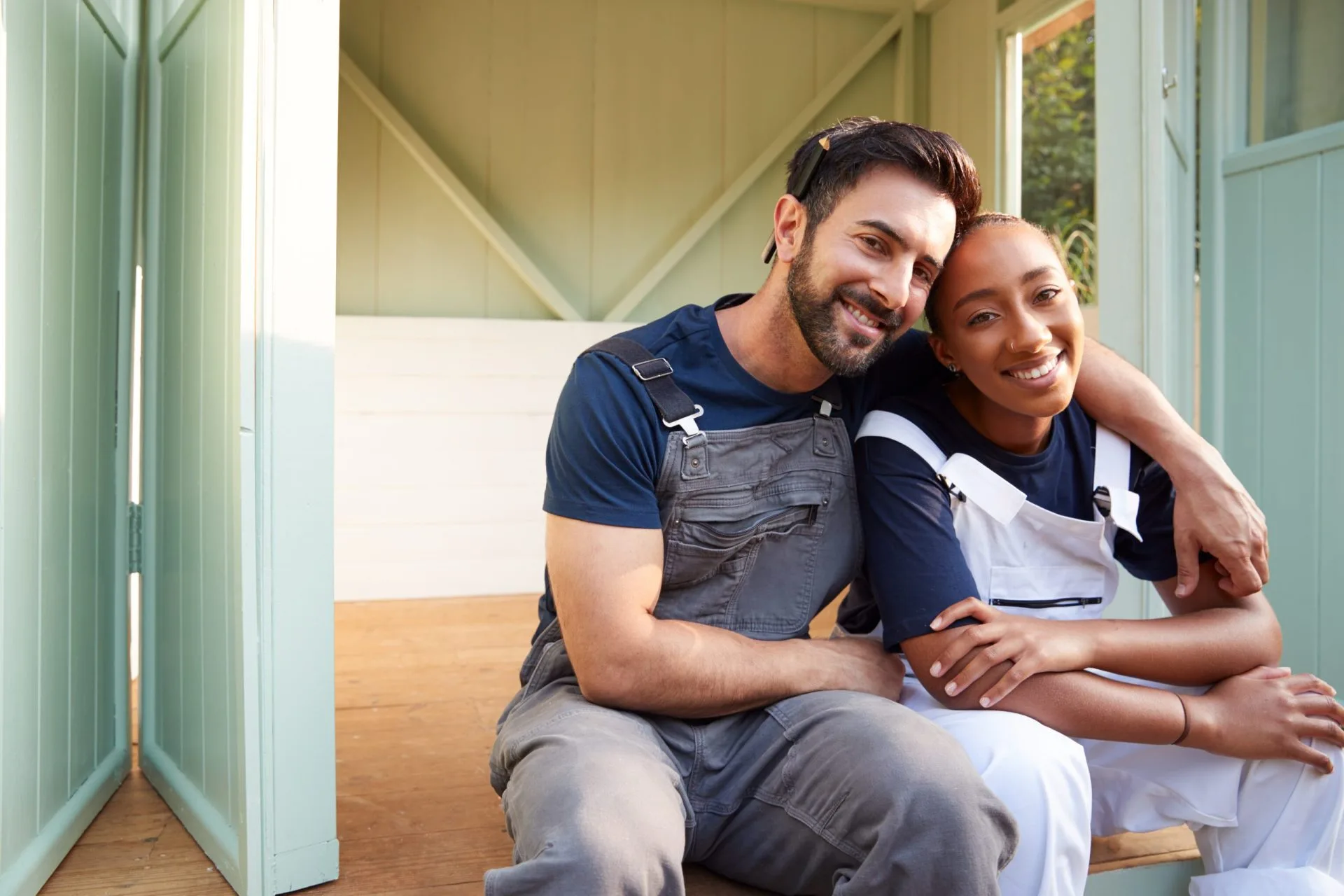 Portrait Of Couple Taking A Break From Building Outdoor Summerhouse In Garden with help from resurgence program